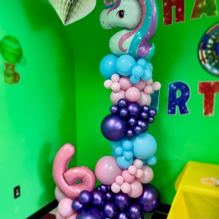 Unicorn-topped balloon column in pink, blue and purple