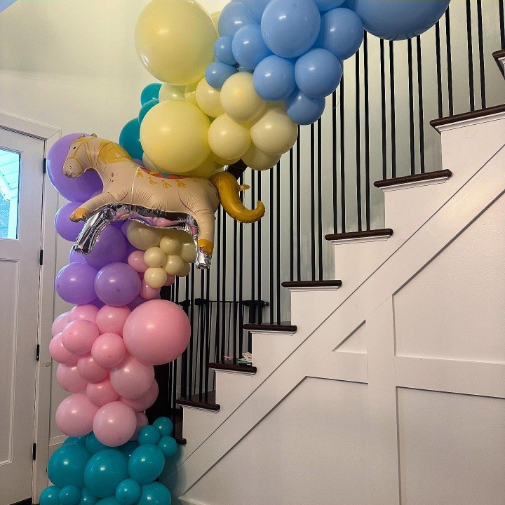 Pastel balloon garland running up a staircase banister