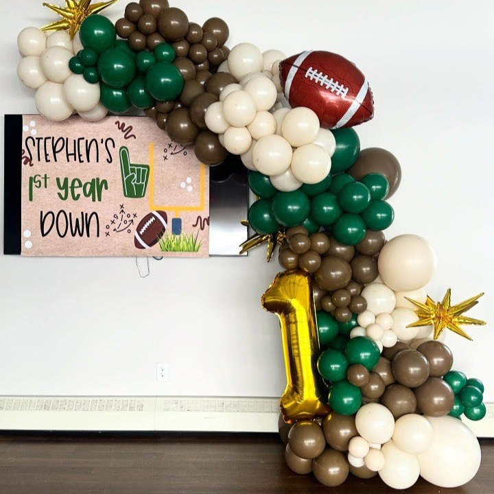 Football-themed balloon garland in green, brown and cream